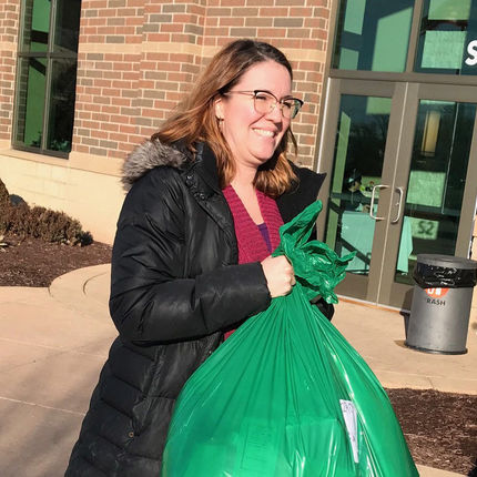 Amanda Skofstad, assistant director of media relations, helps a family carry their presents to their car.