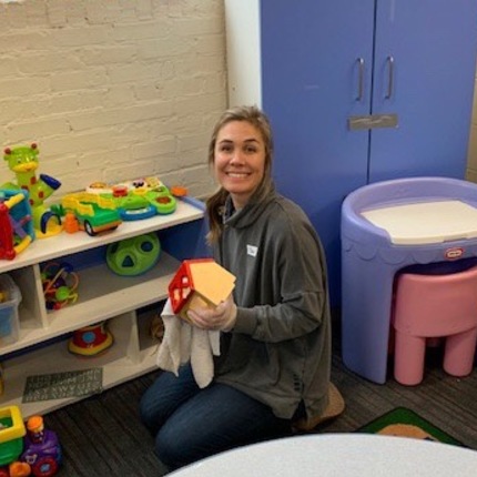 Chloe Leach, senior administrative coordinator in the dean's office,  cleans toys in the playroom at St. Margaret's House.