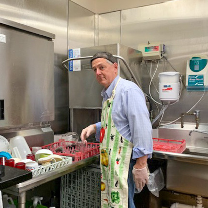 Matt Zyniewicz, the dean's executive administrator, helps out in the kitchen at St. Margaret's House.
