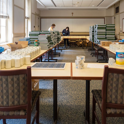 Staff members work in a classroom in Main Building preparing items to be included in memory boxes for the Class of 2020. The gifts were shipped out to the students in time for the degree conferral. (Photo by Barbara Johnston/University of Notre Dame)