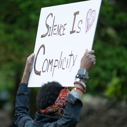 A woman holds up a placard at the Grotto during the 