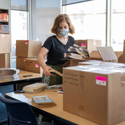 Eva Hornikel, an AmeriCorps member unpacks books in the library at the new Robinson Community Learning Center (RCLC) in South Bend. (Photo by Barbara Johnston/University of Notre Dame)