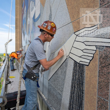 Steve Bryan from C&S Masonry Restoration, LLC, does preventive maintenance on the “Word of Life” mural on the south side of the Hesburgh Library. (Photo by Barbara Johnston/University of Notre Dame)
