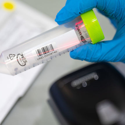 A student worker scans a saliva vial to connect its
unique bar code to the NDID of the person tested.