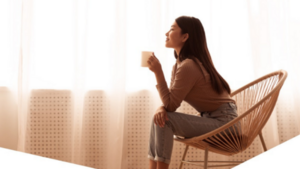 Reflective woman sitting in a chair drinking coffee