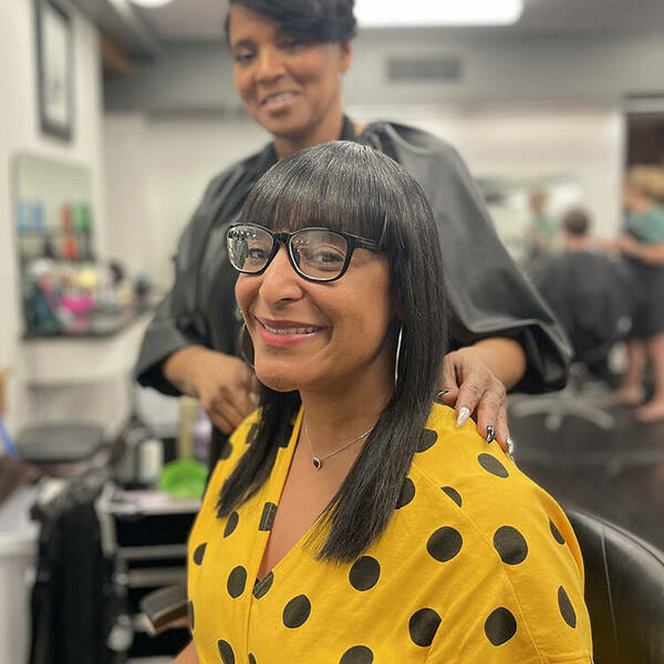 Yvette Wade, the new master stylist at University Hair Stylists, styles a guest's hair.