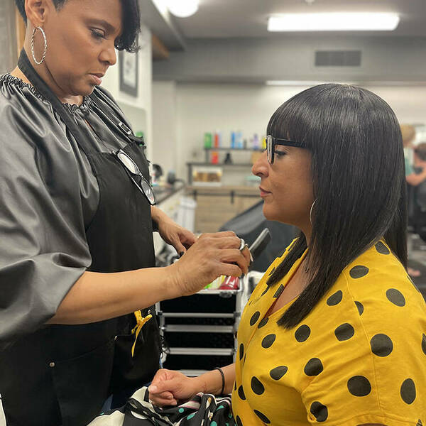 Yvette Wade, the new master stylist at University Hair Stylists, styles a guest's hair.