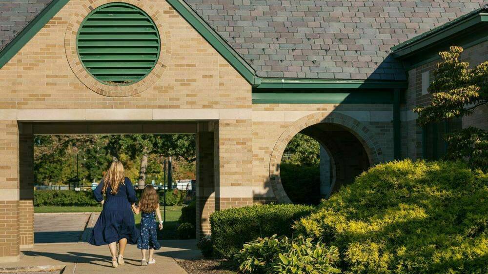 Woman and child walk into child care facility on University campus.