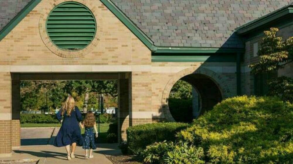 Photo of mom and child walking on campus