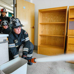 A firefighter sprays water in a room.