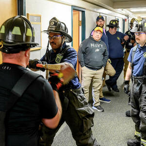 A firefighter breaches a door.